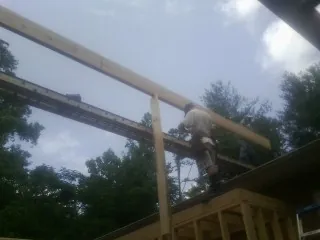 Carpenter setting a ridge beam over a new addition frame — Ice Dam Removal by Roofing Brothers in Newry
