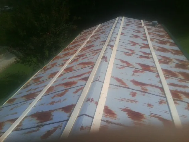 Rusted metal roof panels with new wood purlins before replacement — Storm Damage Roof Repair in Newry by Roofing Brothers