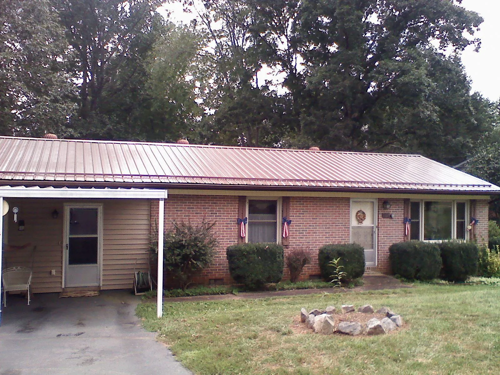 Bronze metal roof and carport on a brick ranch home — Roof Repair work by our crew in Newry